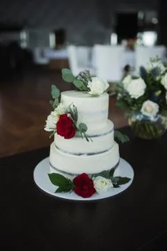 Three-tiered wedding cake decorated with fresh flowers. Fashion cake Stock Photos