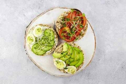 Three toasts with egg, avocado, micro greens, tomatoes and cucumbers . Foto stock