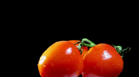 Three tomatoes on  black background in rotation Stock Footage 35916166