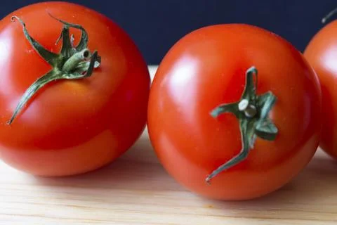 Three tomatoes on a cutting board view Fotos Stock