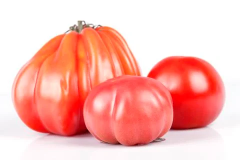 Three tomatoes of different kinds and sizes isolated on white Stock Photos