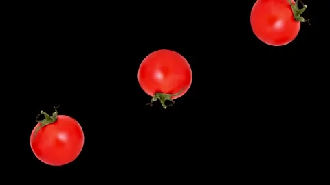 Three tomatoes falling down and rotating on the black background Stock Footage 273226074