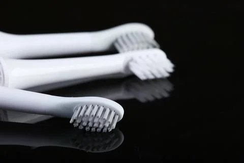 Three toothbrushes on a black reflective background 库存照片