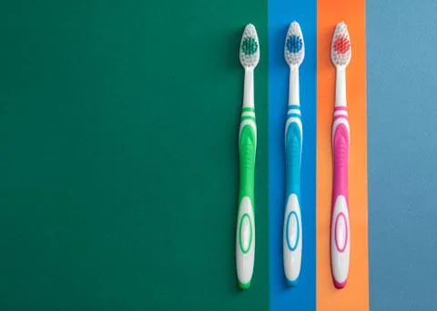 Three toothbrushes on colored paper Foto stock