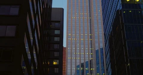 Three towering glass structures converge above bright blue sky, their reflective Stock-Footage 314467396