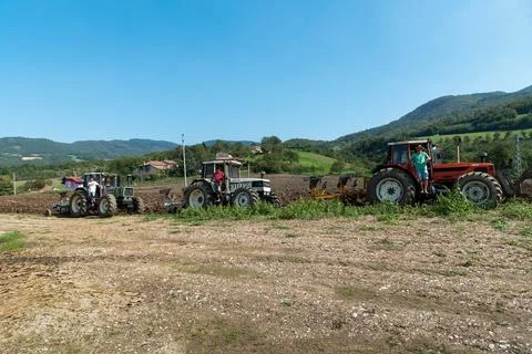 Three tractors plowing a field Stock Photos
