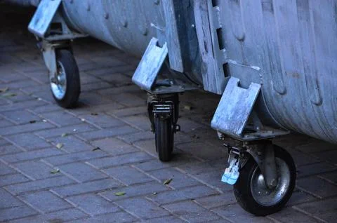 Three trash cans with wheels on the bottom Stock Photos