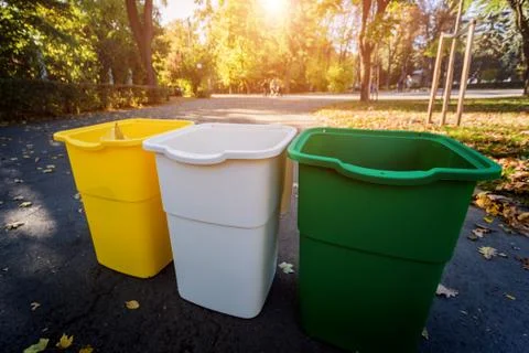 Three trash containers in different color, for sorted waste. Outdoors Stock Photos