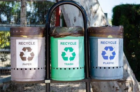 Three trash recycle bin for different materials in a park. Stock Photos