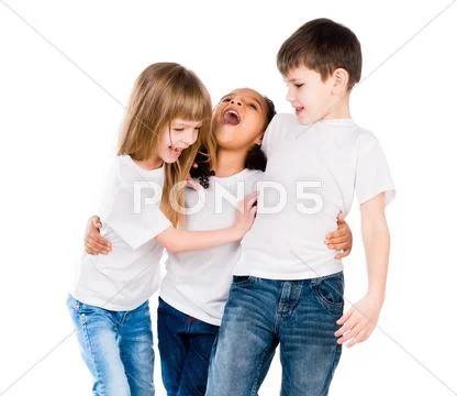 Three trendy children with different complexion laugh and embrace each other Stock Photos