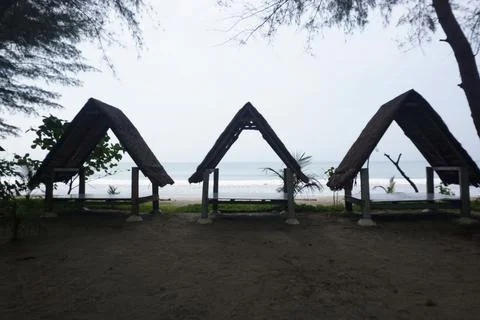 Three triangular gazebos roofed with palm leaves, photo from the front Stock Photos