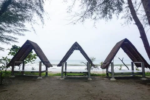 Three triangular gazebos roofed with palm leaves, photo from the front Stock Photos