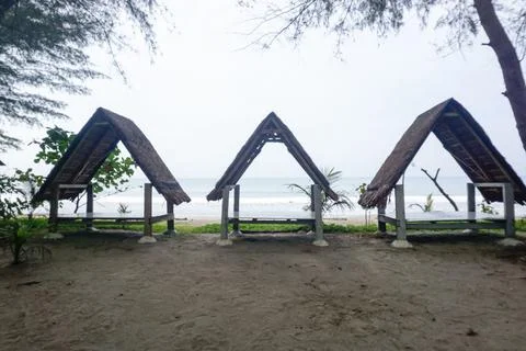 Three triangular gazebos roofed with palm leaves, photo from the front Stock Photos