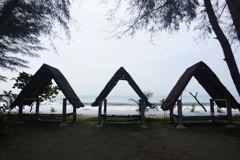 Three triangular gazebos roofed with palm leaves, photo from the front Stock Photos