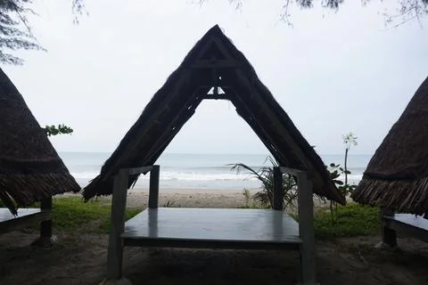 Three triangular gazebos roofed with palm leaves, photo from the front Foto stock