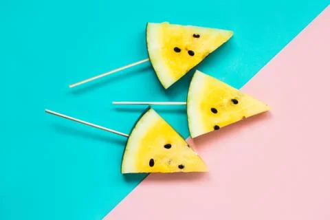 Three triangular ice cream slices on a stick of ripe yellow watermelon Foto stock