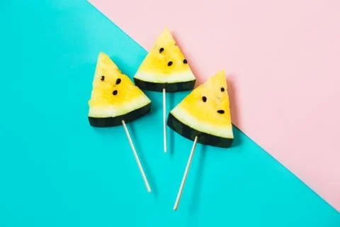 Three triangular ice cream slices on a stick of ripe yellow watermelon Foto stock