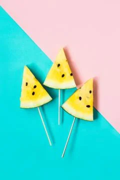 Three triangular ice cream slices on a stick of ripe yellow watermelon 스톡 사진
