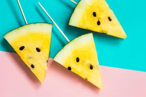 Three triangular ice cream slices on a stick of ripe yellow watermelon 写真素材