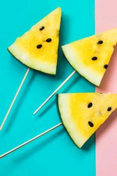 Three triangular ice cream slices on a stick of ripe yellow watermelon Stock Photos