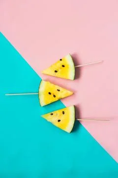 Three triangular ice cream slices on a stick of ripe yellow watermelon Stock Photos