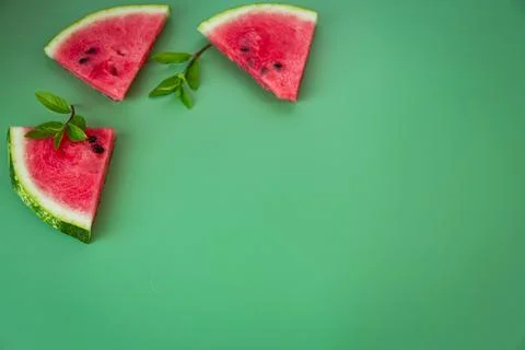 Three triangular pieces of watermelon and mint on the table Stock Photos