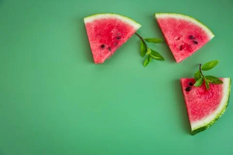 Three triangular pieces of watermelon and mint on the table Stock Photos