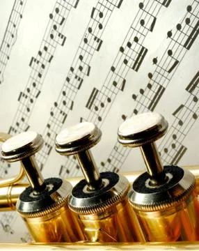 Three trumpet valves in front of notes 写真素材
