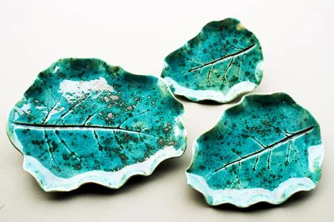 Three turquoise ceramic plates with leaf imprint textured glaze Stock Photos