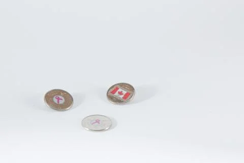 Three twenty five cent canadian coins with symbols in middle canadian flag ai Stock Photos