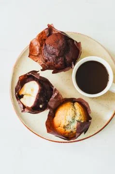 Three type of muffins and a cup of coffy on a plate. White background. Stock Photos