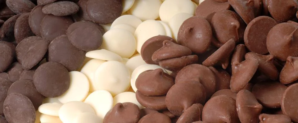 Three types of chocolate chips, dark, white and semi-sweet Stock Photos
