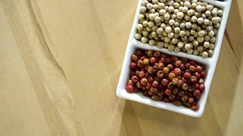 Three types of peppercorns in a white ceramic dish Video stock 333811040