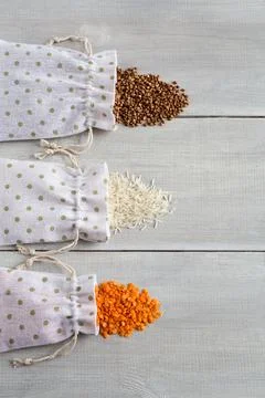 Three types of raw cereals buckwheat, rice and lentils in canvas bags on wh.. Stock Photos