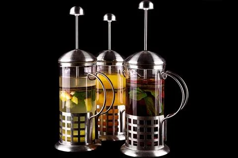 Three types of tea with mint, sea buckthorn and lemon in glass teapots Stock Photos