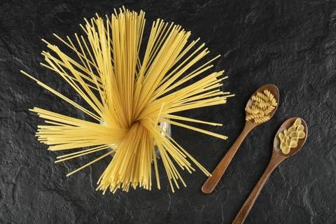 Three types of uncooked pasta on a black background Stock Photos