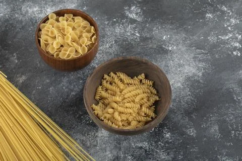 Three types of uncooked pasta on a marble background Stock Photos