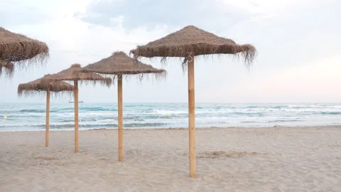 Three umbrellas are on a beach, with the ocean in the background Stock Footage 278150616