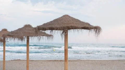 Three umbrellas are on the beach, with one of them being numbered 3 Stock Footage 278150620