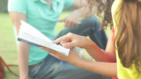 Three unrecognizable students revising material with the help of synopsis Stock Footage 39834087