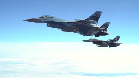 Three U.S. Air Force F-16 Aggressor aircraft flying side by side above clouds Stock Footage 277262304