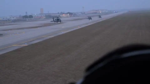 Three U.S. Air Force HH-60G Pave Hawk helicopters approaching runway at dusk Stock Footage 299714312