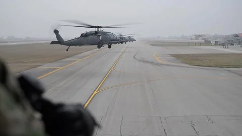 Three U.S. Air Force HH-60G Pave Hawk helicopters hovering above runway Stock Footage 299714313