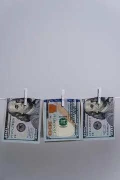 Three US Dollar Bills Hanging Upside Down For Money Laundering Concept Stock Photos