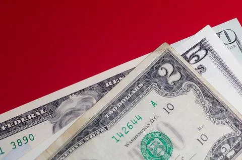Three US dollar bills layered to form number 250 on a red background. Financi Stock Photos