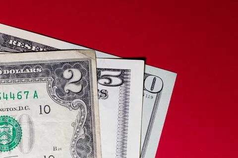 Three US dollar bills layered to form number 250 on a red background. Financi Stock Photos