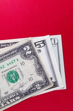 Three US dollar bills layered to form number 250 on a red background. Financi Stock Photos