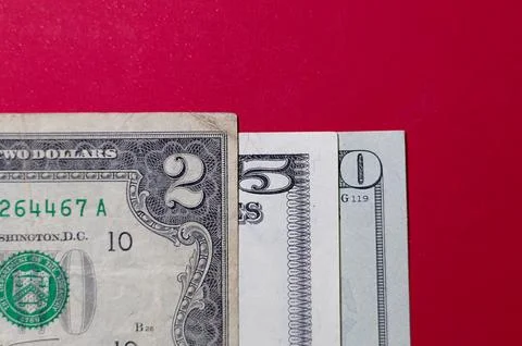 Three US dollar bills layered to form number 250 on a red background. Financi Stock Photos
