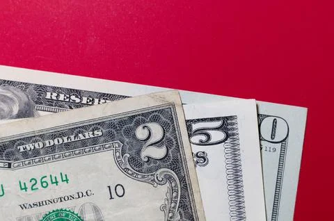 Three US dollar bills layered to form number 250 on a red background. Finan.. Stock Photos