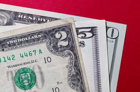 Three US dollar bills layered to form number 250 on a red background. Financi Stock Photos